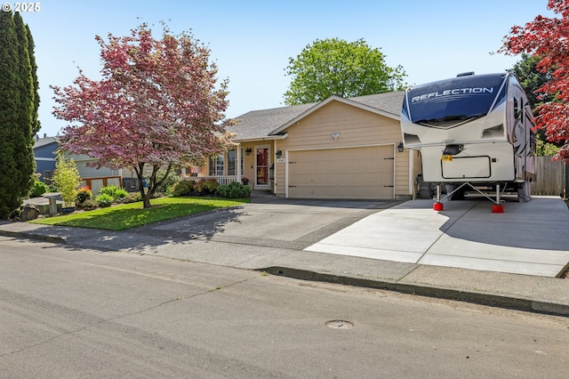 view of front of property featuring a front yard, concrete driveway, and a garage