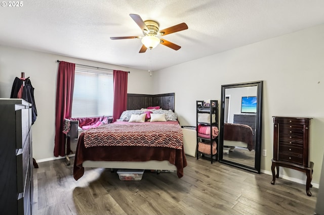 bedroom featuring a ceiling fan, baseboards, a textured ceiling, and wood finished floors