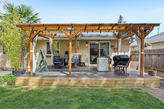rear view of property featuring fence, a yard, a pergola, a wooden deck, and outdoor dining area