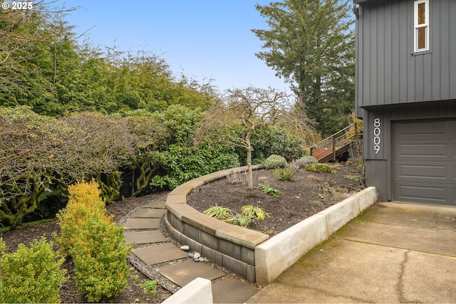 view of yard with a garage and stairs