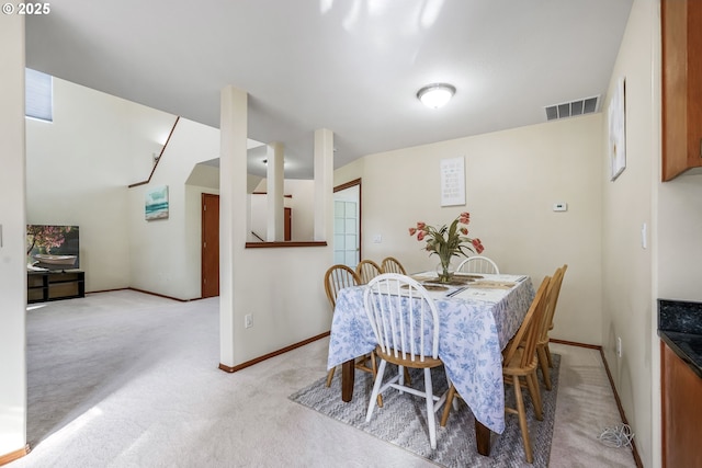 dining area featuring light carpet, baseboards, and visible vents