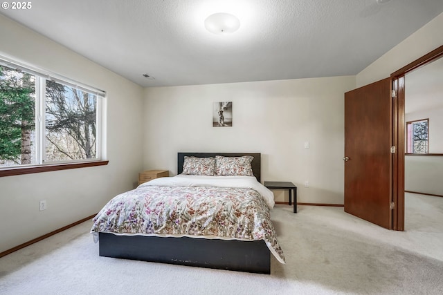 carpeted bedroom featuring a textured ceiling, visible vents, and baseboards