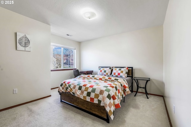 bedroom featuring a textured ceiling, carpet flooring, visible vents, and baseboards