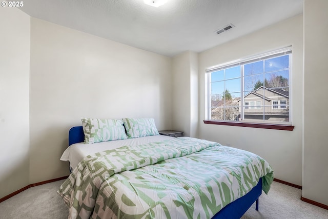 bedroom with carpet, visible vents, and baseboards