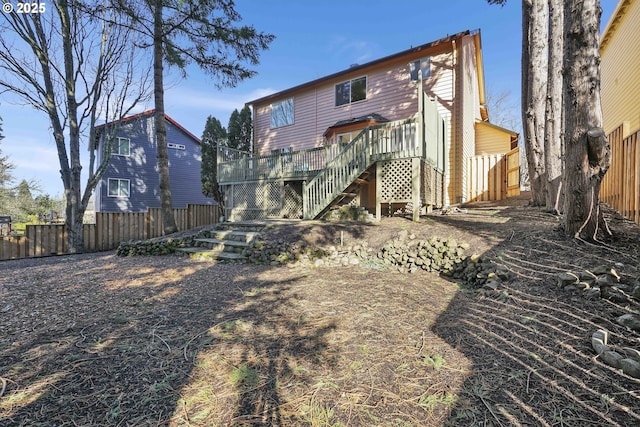 rear view of property featuring stairs, fence, and a wooden deck