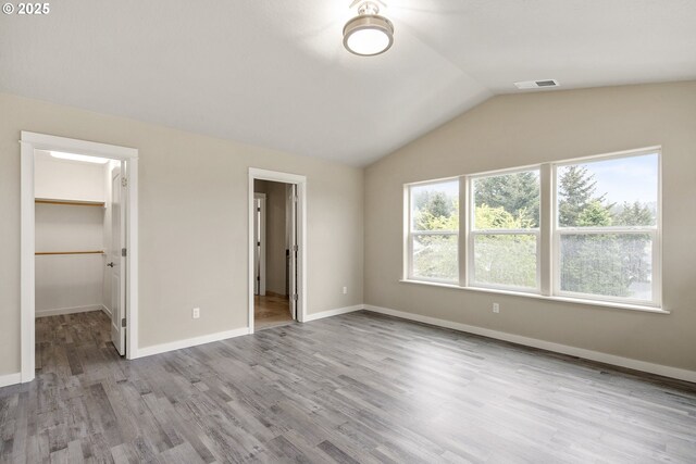 1516 Samuel Dr, Cottage Grove, OR 97424 - unfurnished bedroom featuring lofted ceiling, wood finished floors, a spacious closet, and baseboards