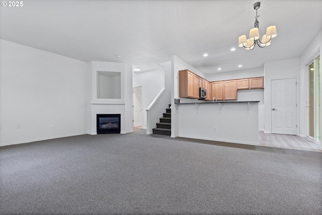 unfurnished living room with dark colored carpet and an inviting chandelier