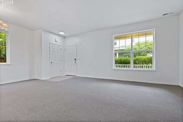 spare room with carpet flooring and an inviting chandelier