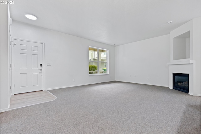 unfurnished living room featuring light colored carpet