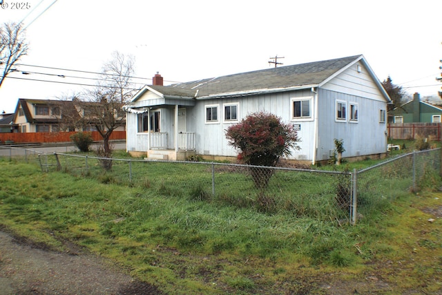 view of front of home with a fenced front yard and a chimney