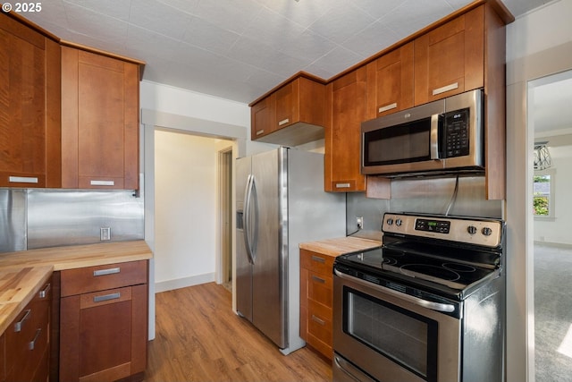 512 Evergreen Dr, Tillamook, OR 97141 - kitchen featuring appliances with stainless steel finishes, butcher block counters, brown cabinets, and light wood-style flooring