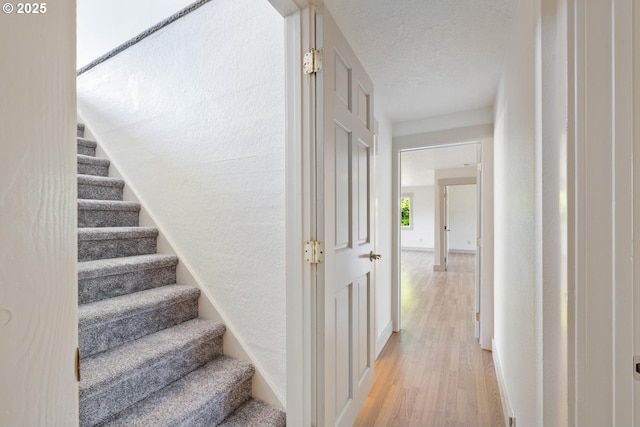 512 Evergreen Dr, Tillamook, OR 97141 - stairway with wood finished floors, a textured ceiling, and baseboards