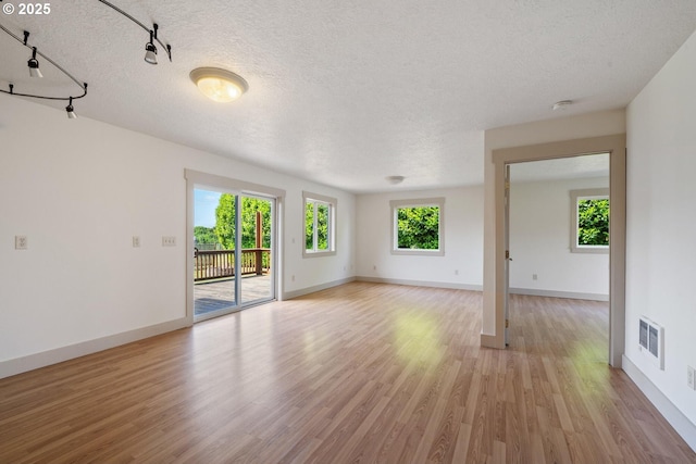 512 Evergreen Dr, Tillamook, OR 97141 - unfurnished room with a textured ceiling, baseboards, light wood-type flooring, and a smoke detector