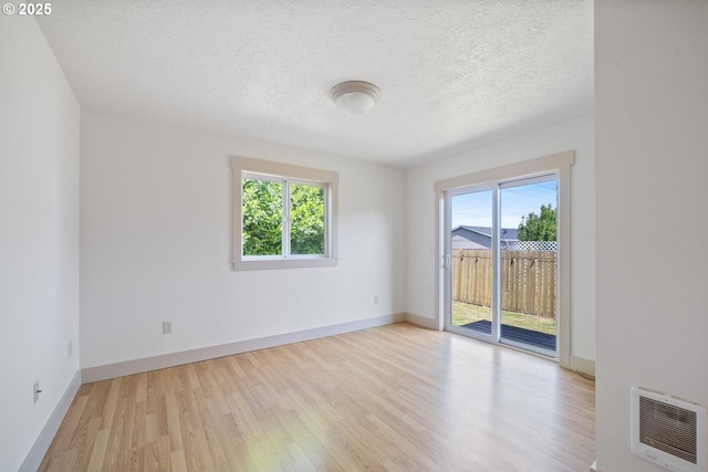 512 Evergreen Dr, Tillamook, OR 97141 - spare room with healthy amount of natural light, light wood-type flooring, a textured ceiling, baseboards, and heating unit