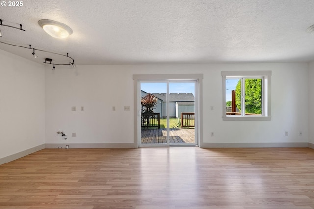 512 Evergreen Dr, Tillamook, OR 97141 - empty room featuring a textured ceiling, light wood-type flooring, and baseboards