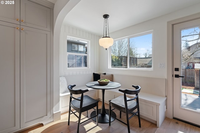 3660 SE Henderson St, Portland, OR 97202 - dining room featuring arched walkways, light wood-style floors, breakfast area, and a healthy amount of sunlight