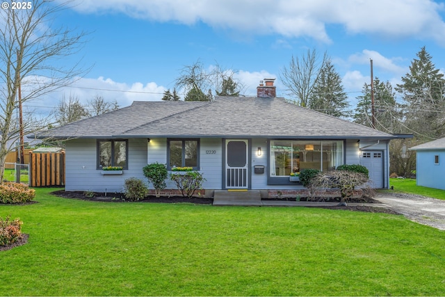 ranch-style home featuring driveway, a garage, a front lawn, and roof with shingles