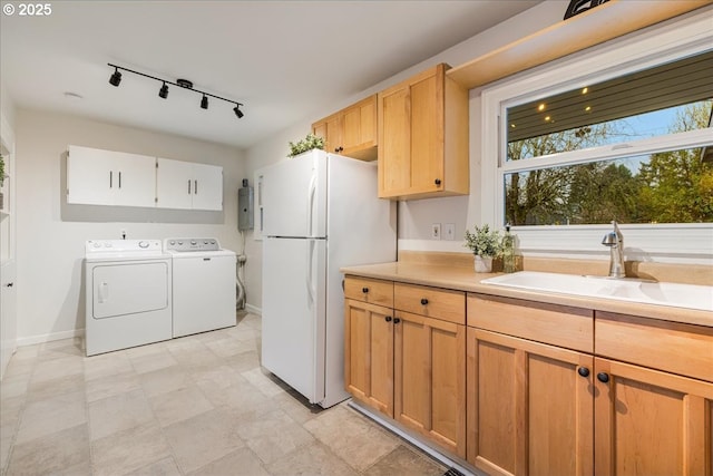 laundry area with baseboards, washer and clothes dryer, and a sink