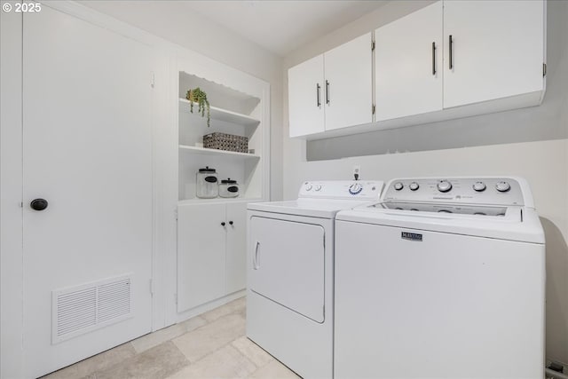 laundry room with visible vents, cabinet space, and washer and clothes dryer