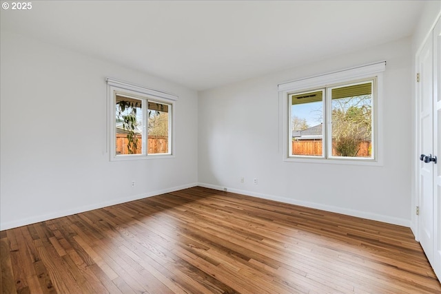 unfurnished room with hardwood / wood-style flooring and baseboards