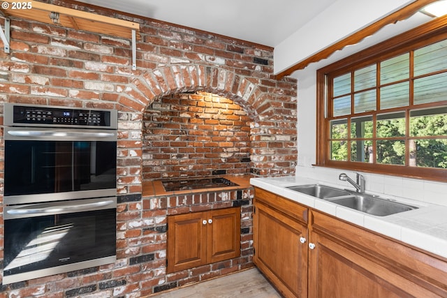 17753 Powers Creek Loop Rd, Silverton, OR 97381 - kitchen featuring double oven, gas cooktop, tile countertops, light wood-type flooring, and brown cabinetry