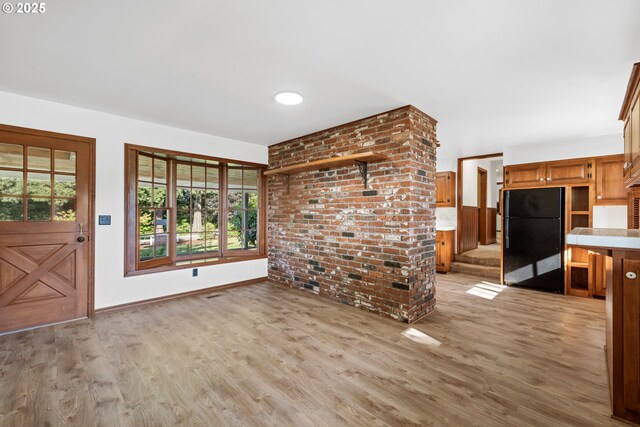 17753 Powers Creek Loop Rd, Silverton, OR 97381 - unfurnished living room featuring healthy amount of natural light, light wood-style floors, and brick wall
