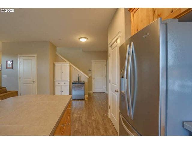 kitchen featuring light countertops, wood finished floors, and stainless steel fridge with ice dispenser