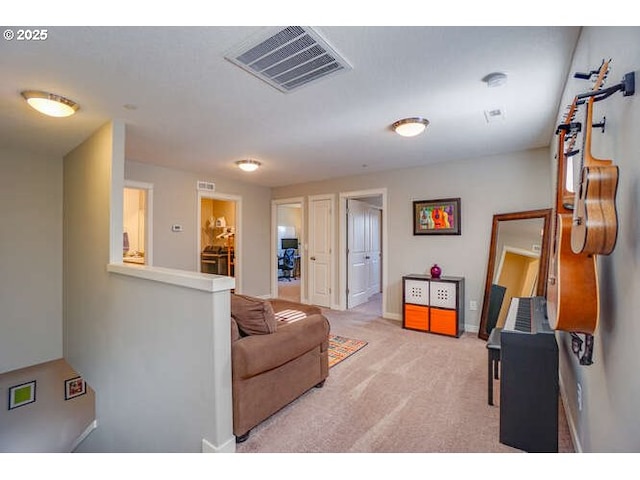 carpeted living area with baseboards and visible vents