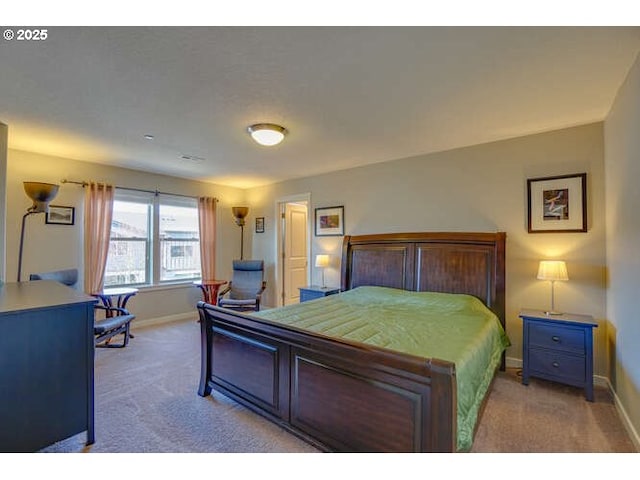 bedroom with baseboards and light colored carpet