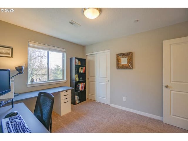 office featuring visible vents, baseboards, and light colored carpet