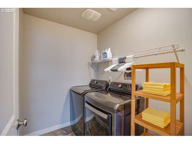 clothes washing area featuring laundry area, baseboards, and independent washer and dryer