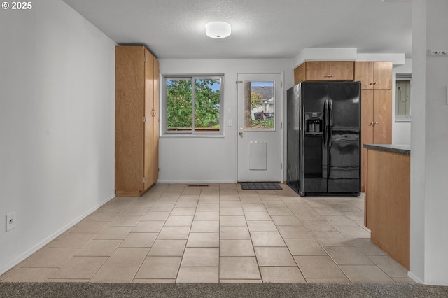 345 S 11th St, Saint Helens, OR 97051 - kitchen featuring black fridge, baseboards, light tile patterned floors, and a textured ceiling