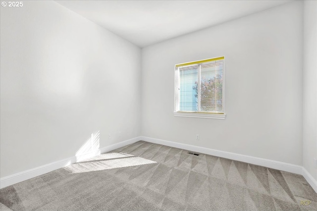 spare room with light colored carpet and baseboards
