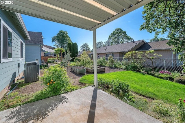 view of yard featuring a garden, a patio, cooling unit, and a residential view
