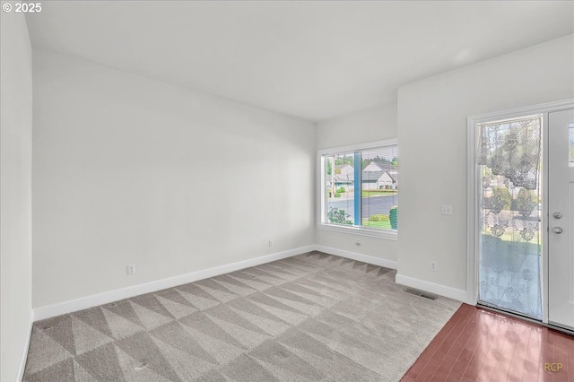 carpeted spare room featuring baseboards