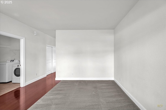 unfurnished room featuring separate washer and dryer, baseboards, and wood finished floors