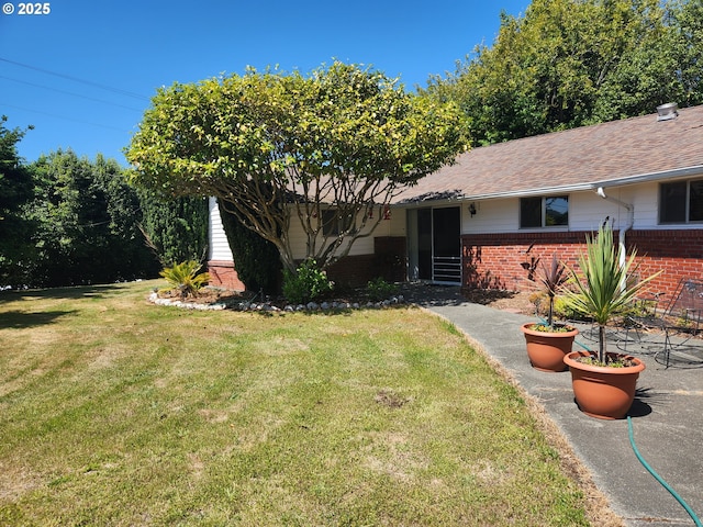 95169 Vista Loop, Gold Beach, OR 97444 - view of front of house featuring brick siding, a front lawn, and a shingled roof