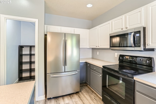 1219 34th Pl, Forest Grove, OR 97116 - kitchen featuring appliances with stainless steel finishes, gray cabinets, light countertops, light wood-type flooring, and white cabinetry