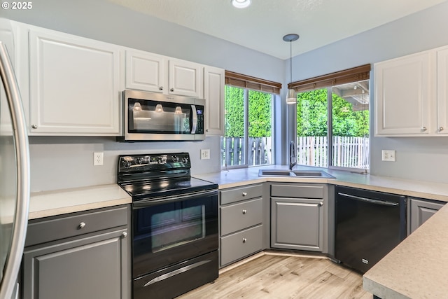 1219 34th Pl, Forest Grove, OR 97116 - kitchen with black appliances, gray cabinetry, light wood-style floors, and white cabinetry