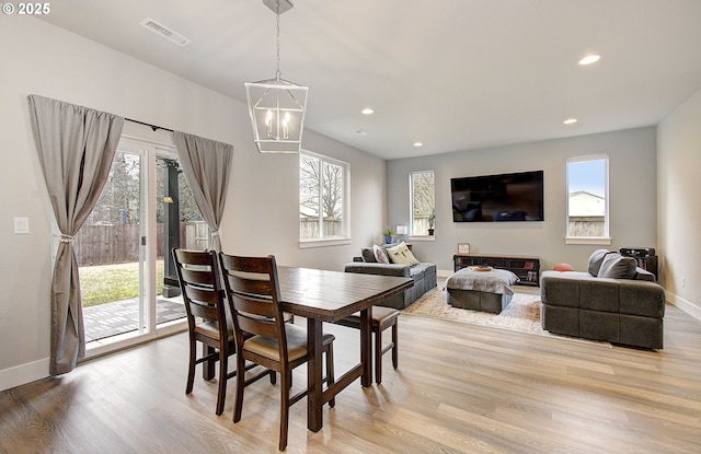 dining space with a notable chandelier and light hardwood / wood-style flooring