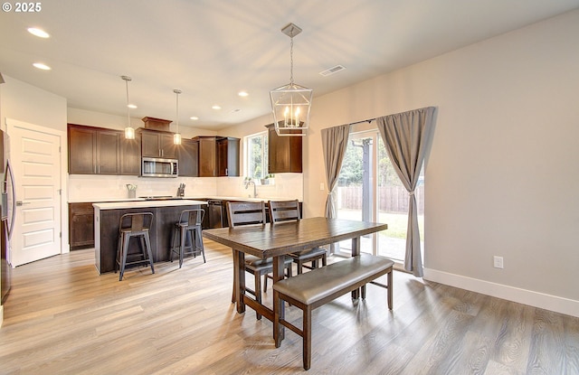 dining space featuring an inviting chandelier and light hardwood / wood-style floors