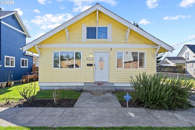 bungalow-style house with fence