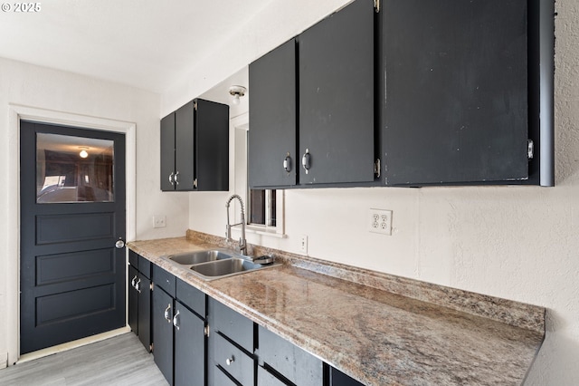 kitchen with light countertops, light wood-type flooring, and a sink