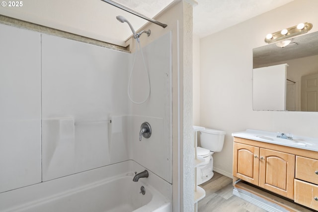 bathroom with wood finished floors, shower / washtub combination, vanity, and toilet