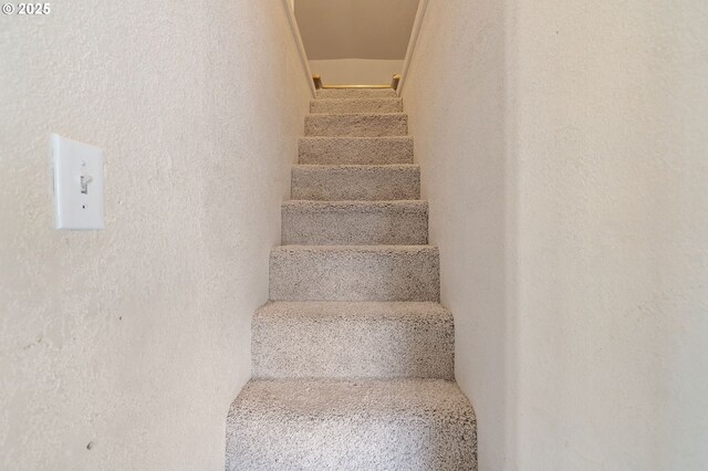 staircase featuring a textured wall