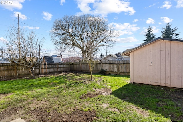 view of yard with a fenced backyard, a storage unit, and an outdoor structure