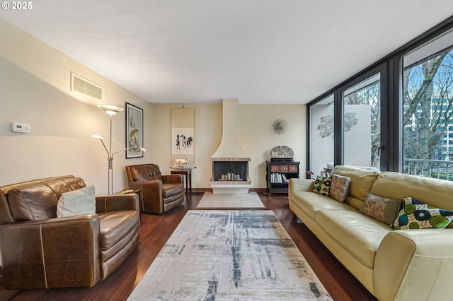 living room with dark hardwood / wood-style flooring and floor to ceiling windows