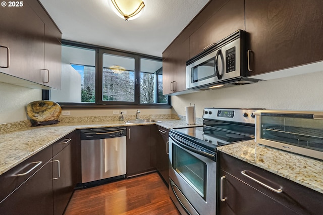 kitchen with stainless steel appliances, dark brown cabinets, dark hardwood / wood-style floors, and sink