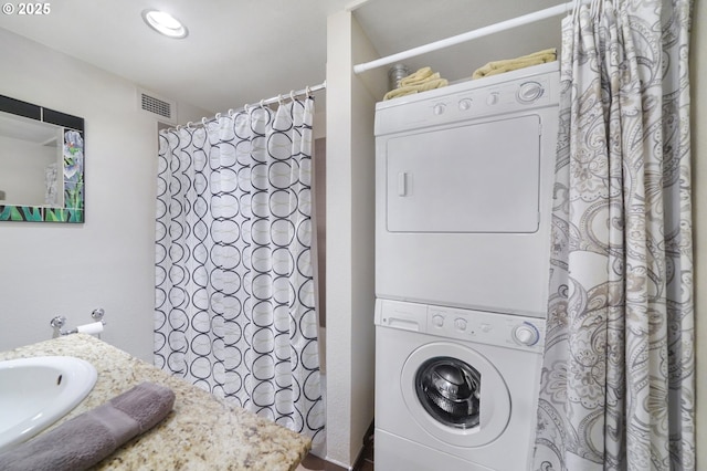 clothes washing area with sink and stacked washer / drying machine