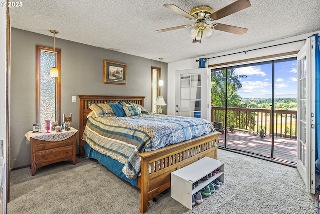 carpeted bedroom with ceiling fan, access to exterior, and a textured ceiling